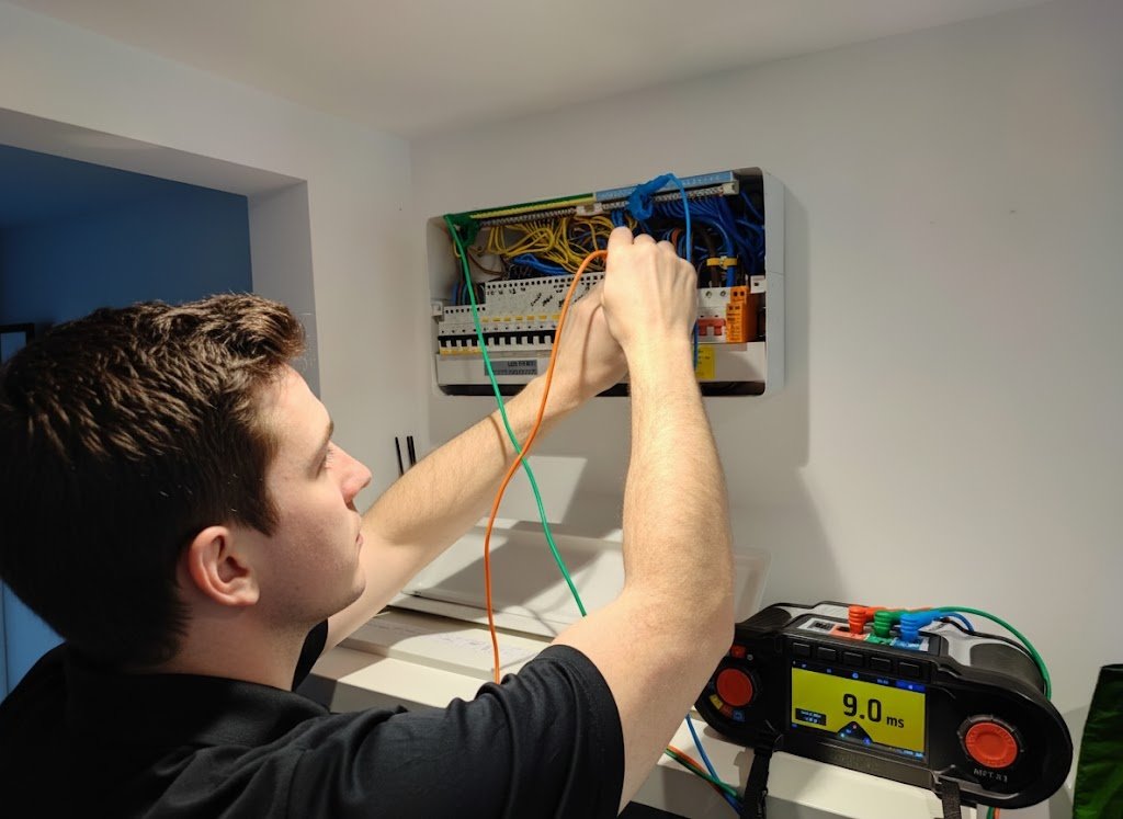 Electrician working by torchlight on a consumer unit